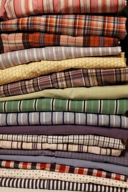 istock close-up of a stack of neatly folded clothing textiles mens button down shirts. 2200227399