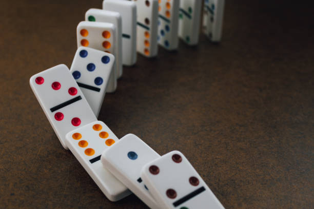 istock dominoes in the process of falling down 2200227502