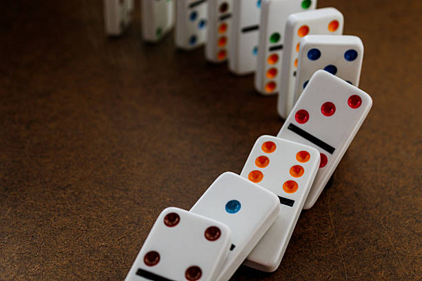 istock dominoes in the process of falling down 2200227556