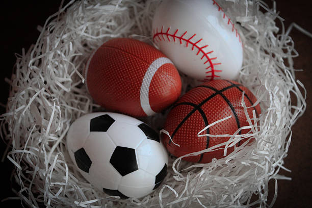 istock abstract nest with sports themed Easter eggs spring backdrop graphic element eggs soccer football baseball basketball on white grass isolated on dark background 2200229957