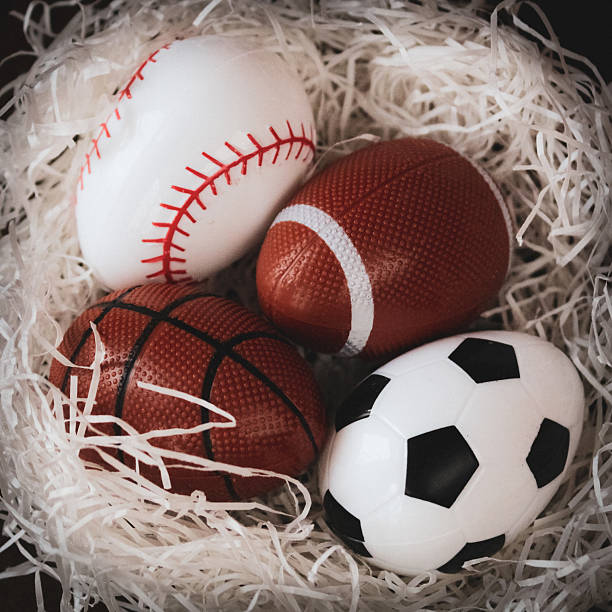 istock abstract nest with sports themed Easter eggs spring backdrop graphic element eggs soccer football baseball basketball on white grass isolated on dark background 2200230073