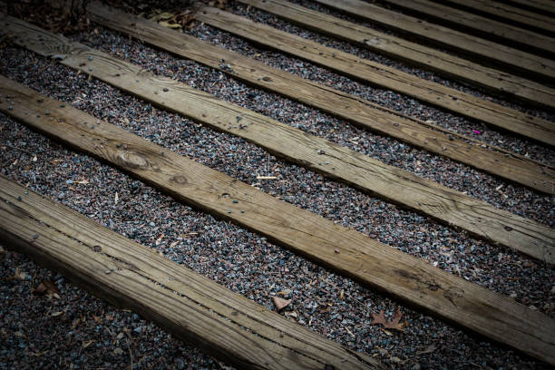 erosion control river bank footpath slight tiered slope made of pebbles wood planks long horizontal boards texture stairs abstract river bank environmental background