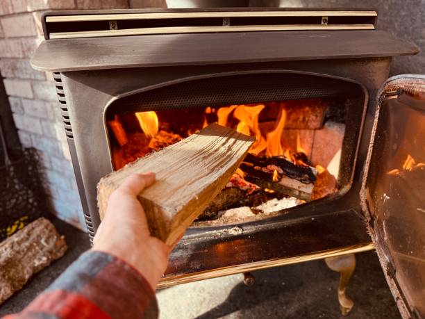 istock Wood Burning Stove Hand Adding Fuel 2200231276