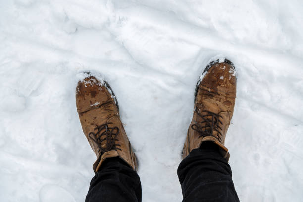 The feet of a person walking in the snow