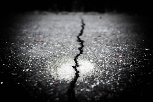 abstract long crack in pavement road metaphor infrastructure future business transportation backdrop