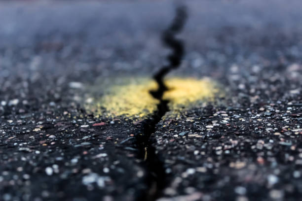 istock abstract long crack in pavement road metaphor infrastructure future business transportation background 2200236796