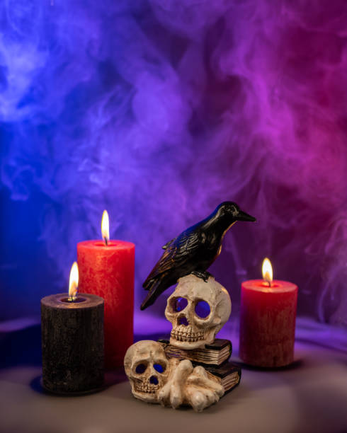 istock Crow figure sitting on the skulls and bones with candles and smoke. 2200237904