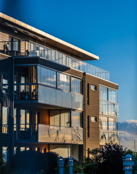 istock modern glass apartment building reflecting sunset sky. 2200240103