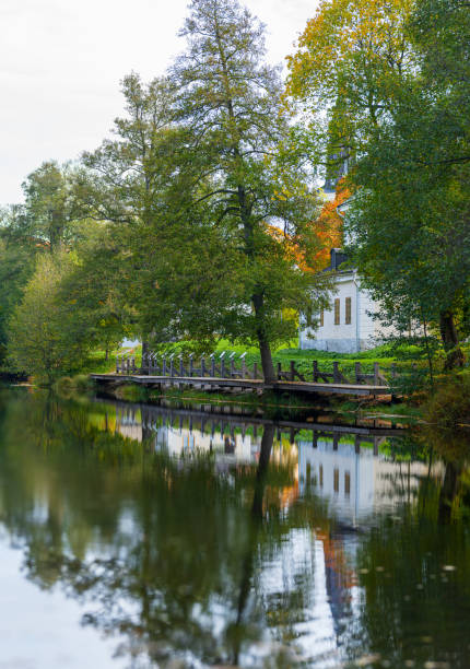 istock scenic riverside with trees and wooden walkway. 2200240116