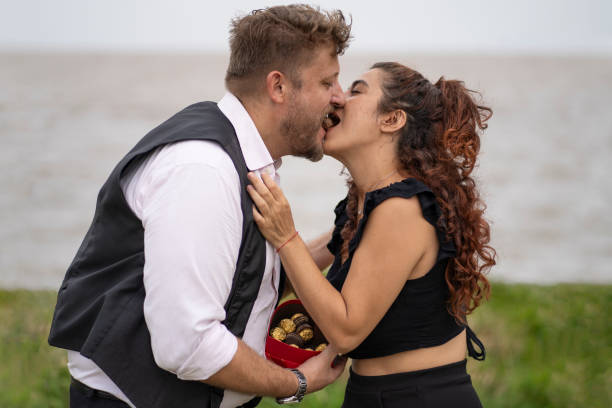 istock Couple kisses while eating chocolate on the beach 2200242318