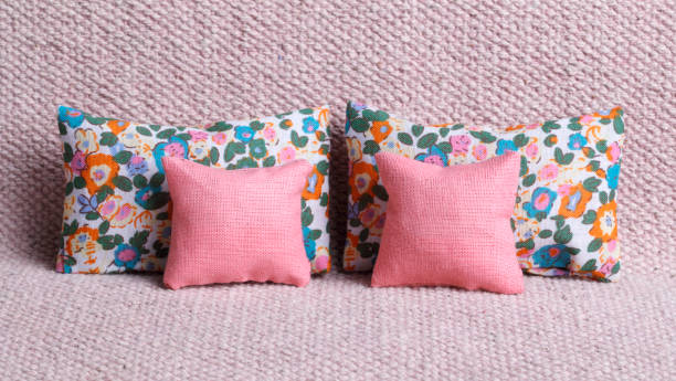 Pink and flowered cushions on sofa