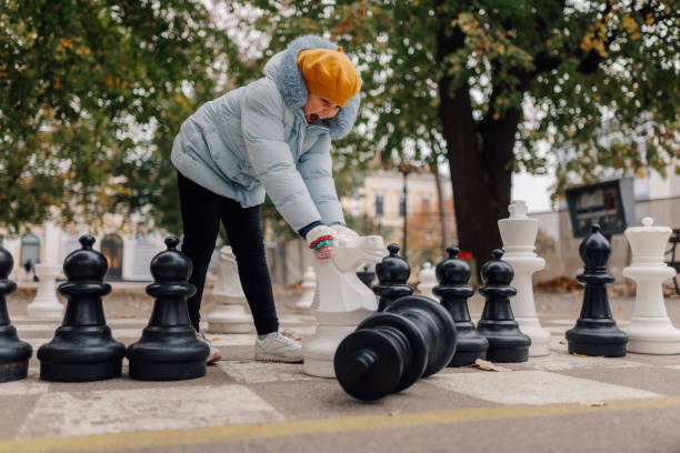 istock Girl playing with giant chess pieces in a park 2200245578