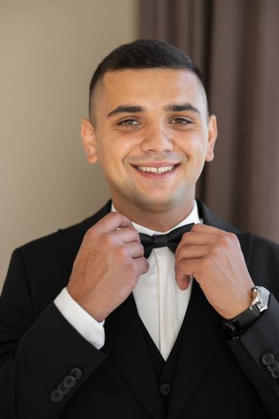 istock Smiling Groom Adjusting Bow Tie Before Wedding Ceremony 2200246516