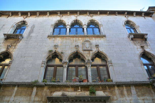 istock A building featuring arched windows and a balcony with plants 2200246731