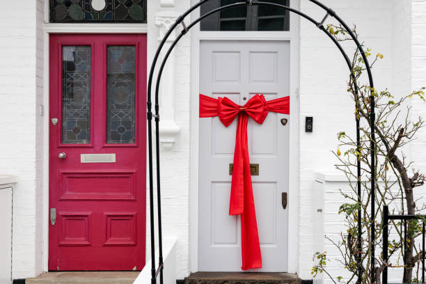 istock White door with a big red bow and a red door next to it 2200247315