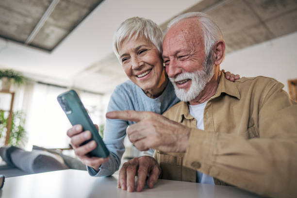 istock Happy senior couple using smartphone at home, enjoying modern technology 2200257524