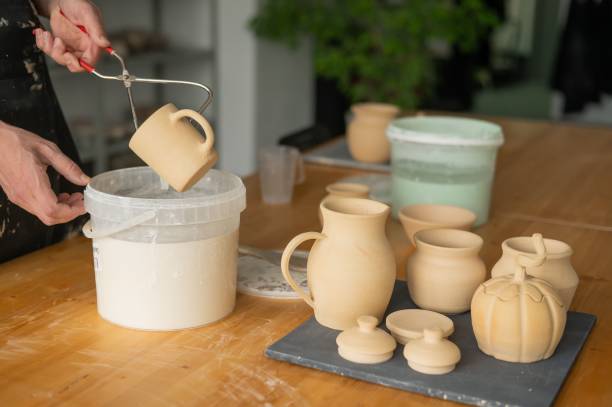 istock Close-up of a potter's hands glazing a ceramic mug. 2200257642