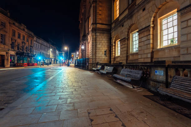 istock Empty street in bath, england at night illuminating disabled parking sign 2200261954