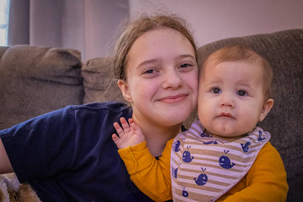 istock Tween girl and baby sister interacting 2200264312
