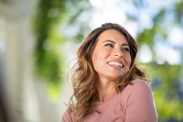 istock Close up beautiful young woman laughing outside 2200268859