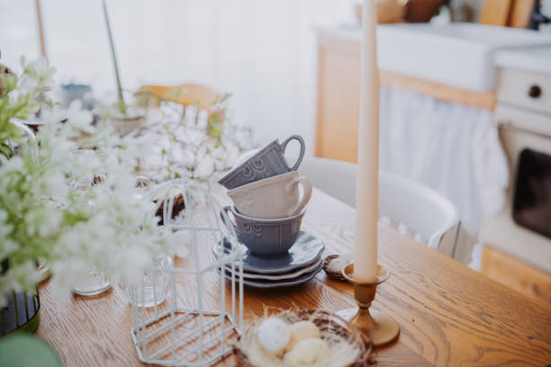 istock Vintage kitchen setting with stacked mugs and a flickering candle on table 2200270074