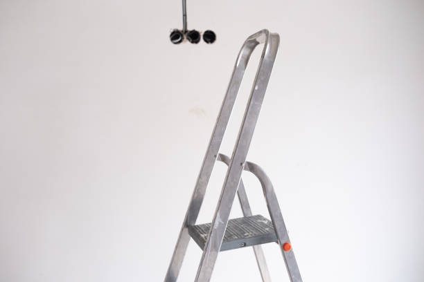 istock Metal ladder positioned under ceiling fixtures during home renovation work 2200270172
