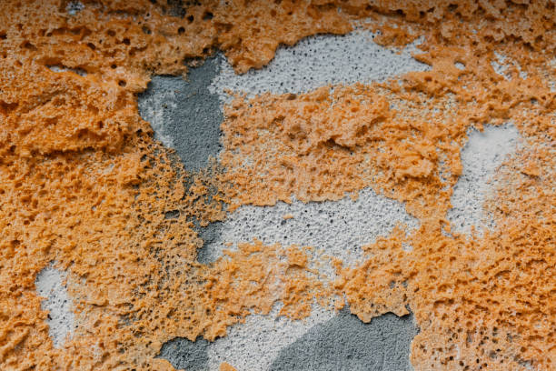 Unique, colorful wall texture reveals layers of orange and gray materials.