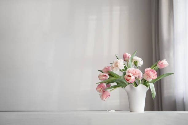 istock pink spring flowers in white ceramic vase on background whhite wall 2200270244