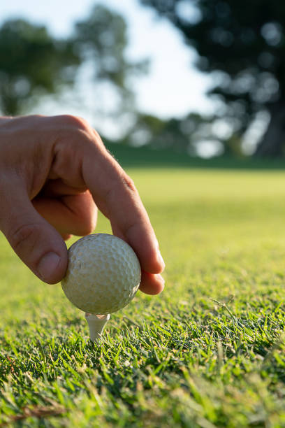 istock A Hand putting golf ball with a tee on the golf course. 2200271241