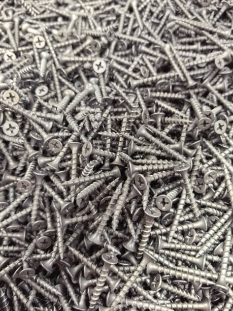 istock Scattered metallic screws on a surface in an industrial space 2200285305