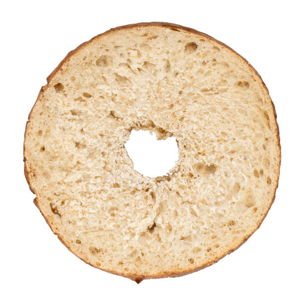 Top view of a whole wheat bagel slice isolated on white background. Crispy crust, airy texture, and porous interior, perfect for breakfast or snacks.
