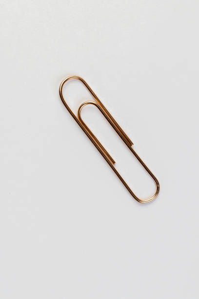 istock large sized copper paper clips lie on white blank paper 2200307211