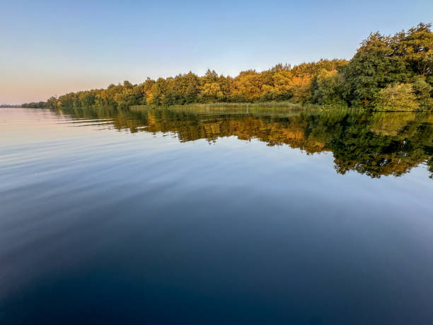 istock A calm lake with trees in the background 2200314688