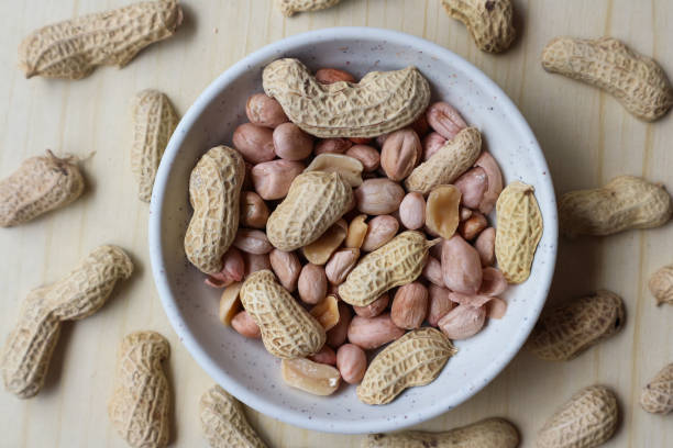 istock Peanuts in a bowl on a wooden table 2200316152