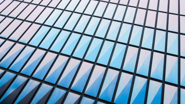 istock A close-up view of a geometric glass facade featuring blue-tinted triangular panels, creating a sleek and modern architectural design 2200319778