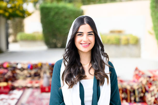 Portrait young Arabian woman wearing traditional clothes and modern fashions standing in front of Majlis