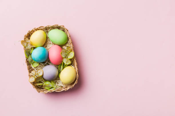 istock Multi colors Easter eggs in the woven basket on colored background . Pastel color Easter eggs. holiday concept with copy space 2200323907