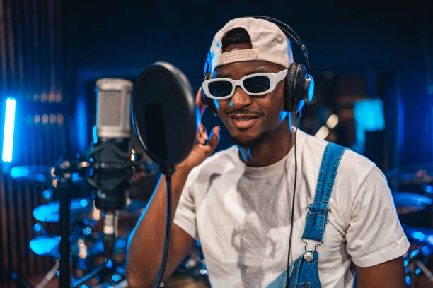 istock Young male singer recording music in professional studio 2200326875