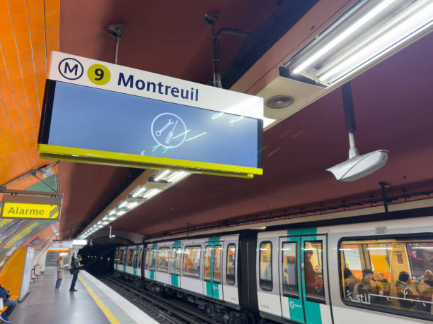 Paris,France-15.02.2025 Commuters gather at Montreuil Metro Station, waiting for trains on a busy day in the heart of the city. The vibrant signage adds to the lively atmosphere.