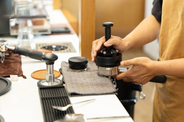 A barista is making coffee with a coffee press
