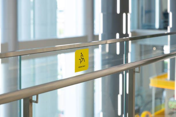 A yellow sign on a glass railing.