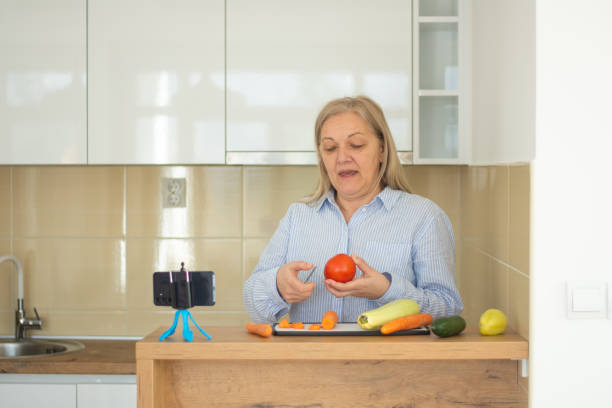 istock Mature woman explaining healthy eating benefits during online cooking masterclass lesson 2200330417