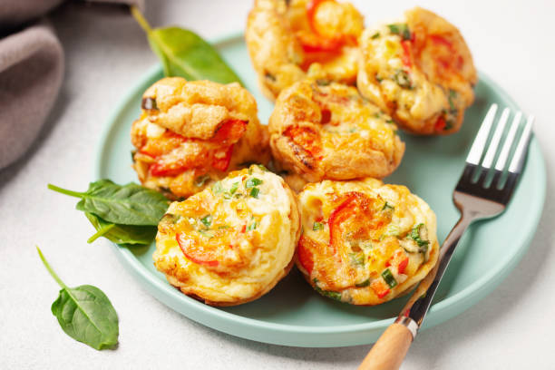 istock Egg muffins ( bites) and spinach leaves  in a plate on a gray background 2200331694