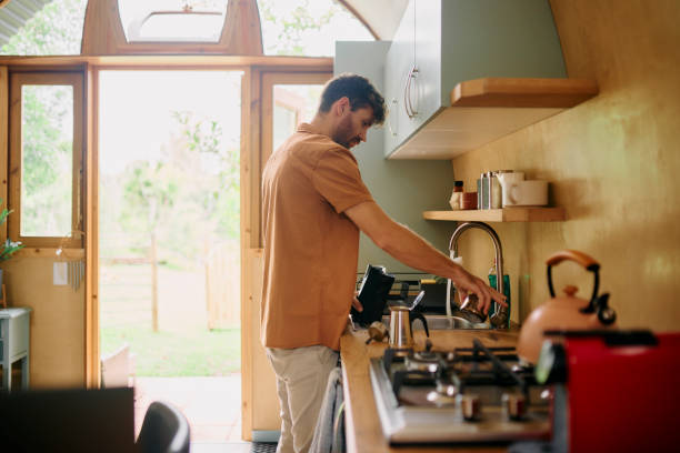 istock Moka pot, man and espresso preparation in kitchen for brewing beverage, morning routine and caffeine break. Person, coffee maker and pouring water in stovetop appliance for drink to start day in home 2200331949