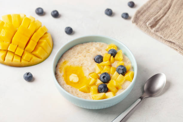 istock Oatmeal porridge with mango and blueberries. Healthy breakfast 2200332620