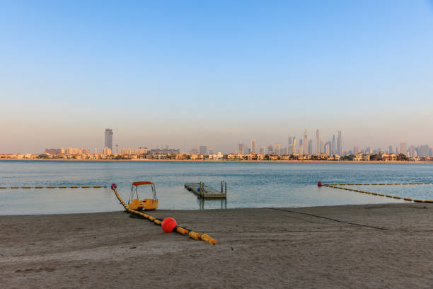 Dubai skyline at dusk, view from the sandy beach across the sea