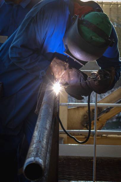 istock Industrial Worker Welding Metal Pipe 2200333890