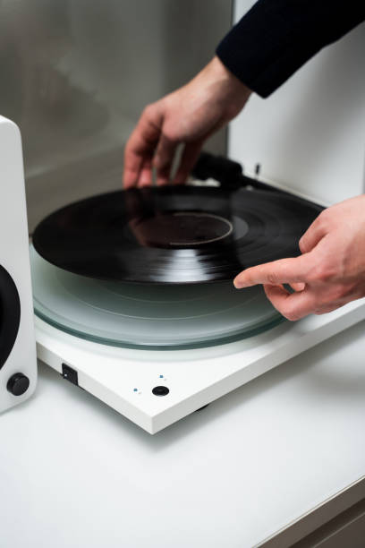 istock Musicians hands adjusting vinyl disc on a needle player close-up. Setting up vinyl speaker system. 2200338115