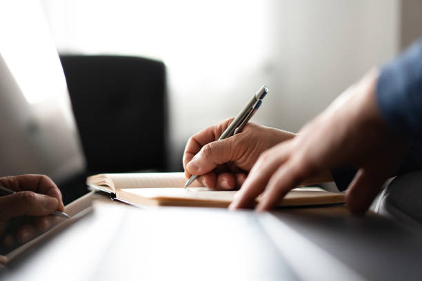 istock Close-up of senior man hands writing in notebook 2200340863