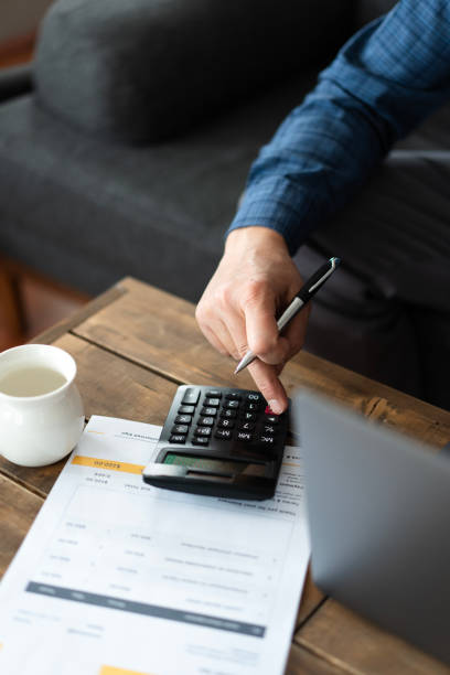 istock Senior man Accountant calculating invoice using calculator and laptop at home office 2200341298